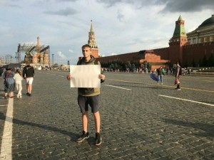 Создать мем: плакат на красной площади, на красной площади человек с плакатом, красная площадь в москве