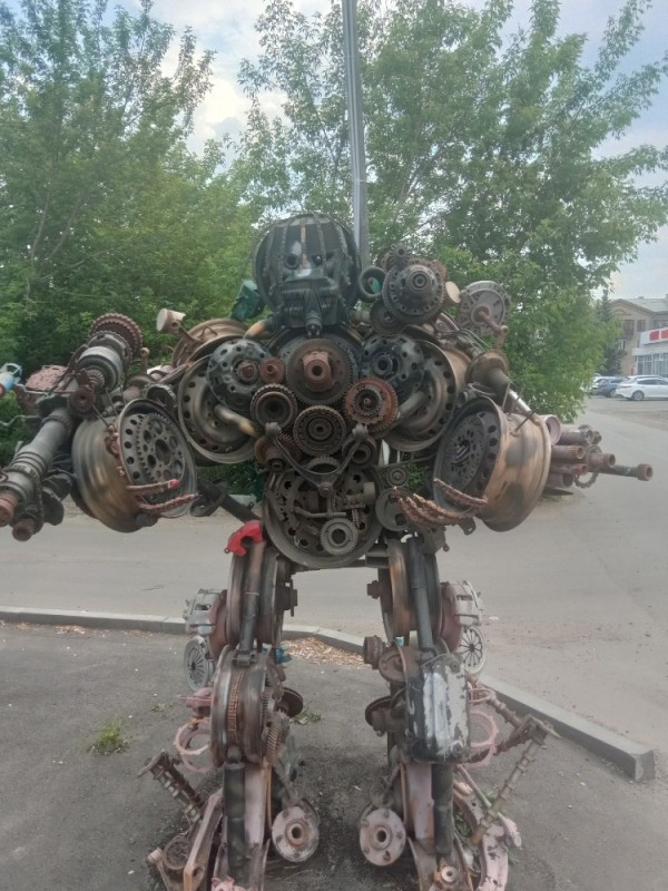 Create meme: scrap metal robot, transformers robots, a robot made of scrap metal in a car service
