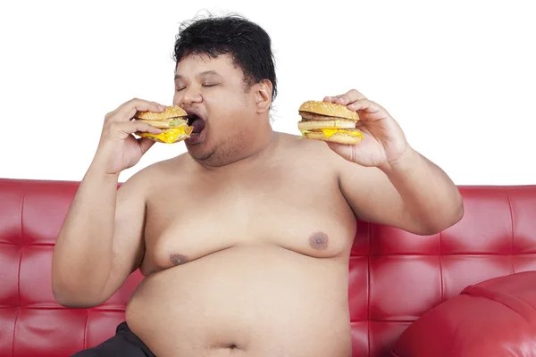 Создать мем: жирный человек на диване с едой, толстый человек с бургером, нальчик