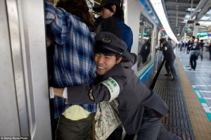 Создать мем: трамбовщик пассажиров в метро, метро токио час пик, заталкиватель в метро япония