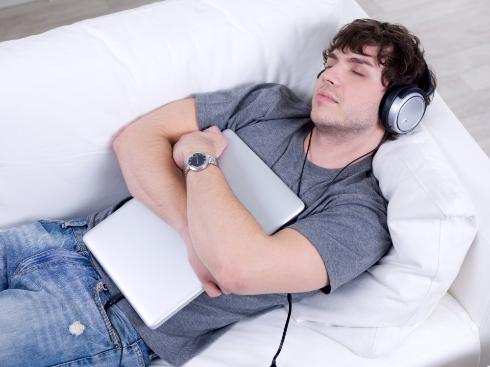 Create meme: Sleeping with headphones on, a man is lying on the couch , Falls asleep with headphones on