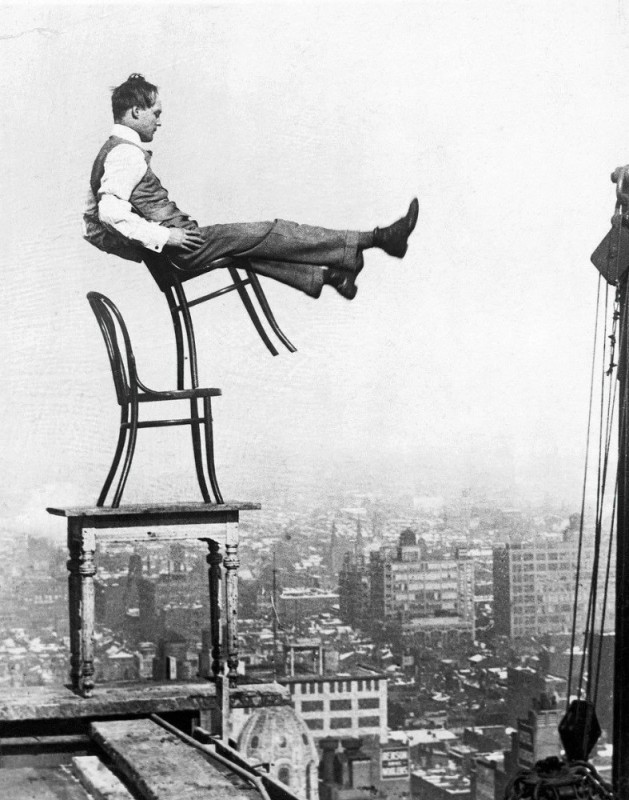 Создать мем: человек на стуле на крыше, нью йорк 1900 год, усидеть на двух стульях