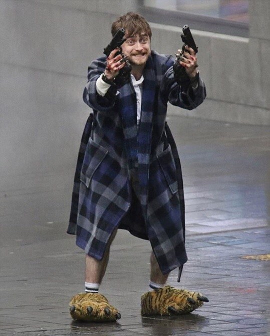 Create meme: Harry Potter , Daniel Radcliffe guns akimbo, Daniel Radcliffe with guns in a Bathrobe