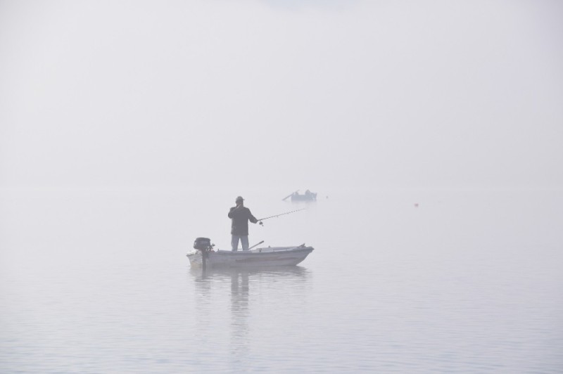 Create meme: a boat in the fog, boat with a fisherman, fisherman on a boat in the fog