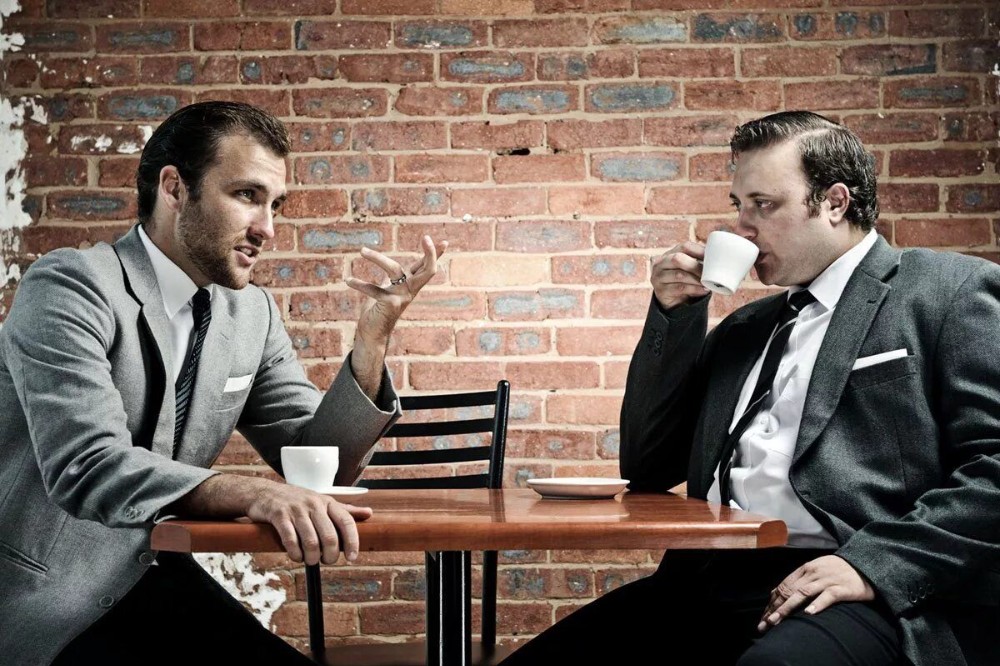 Create meme: a conversation between two men, The man at the table, Two men are talking in a cafe