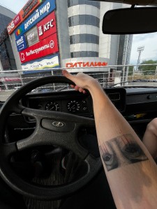 Создать мем: авто, пара девушек, татуированная рука на руле