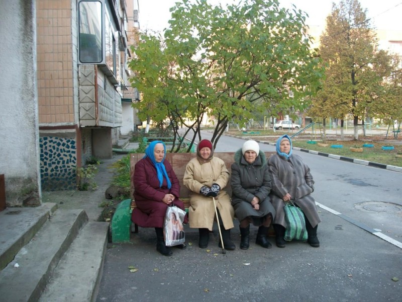 Create meme: grandmother on a bench at the entrance, the grandmother on the bench, grandmother at the door 