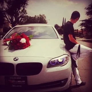 Create meme: a guy with a bouquet of roses near the car, the guy with flowers without a face, a man on a cool bmw at night with roses