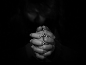 Создать мем: держит крест, человек молится в темноте, tristete