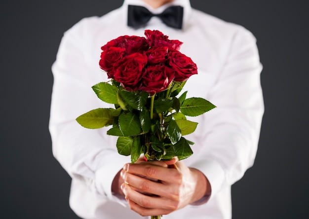 Create meme: a man with a bouquet of red roses, a man with a bouquet, guy with a bouquet of roses