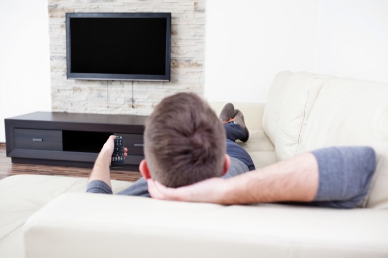 Создать мем: мужчина смотрит телевизор, человек перед телевизором, диван перед телевизором