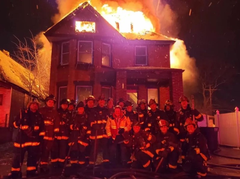 Create meme: firefighters stand against the background of a burning house, firefighters on the background of a burning house, The house that burned down