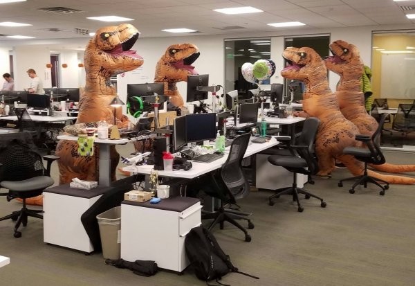 Создать мем: люди в костюмах динозавров в офисе, офисные приколы, динозавры в офисе