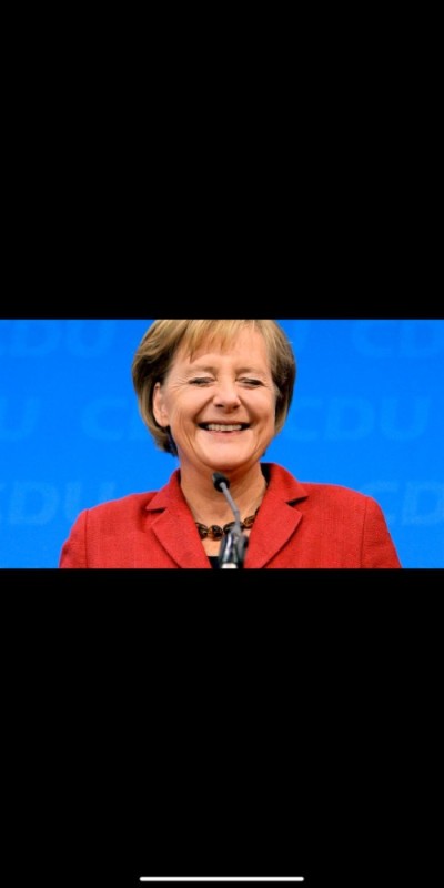 Создать мем: ангела меркель на трибуне, канцлер германии, меркель довольная