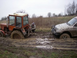 Создать мем: трактор едет по грязи, бездорожье в селе, мтз в грязи