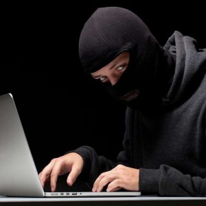 Create meme: hacker, hacker in a Balaclava, hacker in a mask with laptop
