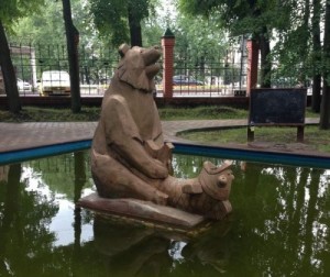 Создать мем: скульптура медведь и форель, скульптура медведь и рыба в парке, странный фонтан медведь с рыбой