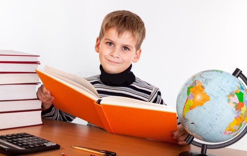 Школьник читает книгу. Ученик читает экономическую географию. Ученик читает физику. Ученик читает учебник в Африке.