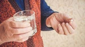 Создать мем: a glass of water, таблетки в руке, старик пьет таблетки